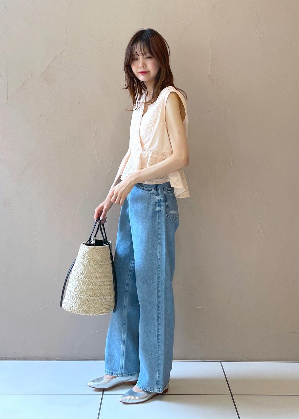 ホワイト系のかごバッグ、ブルー系のデニムパンツ、シルバー系のパンプスを着用したレディースの夏コーディネートの10枚目の写真