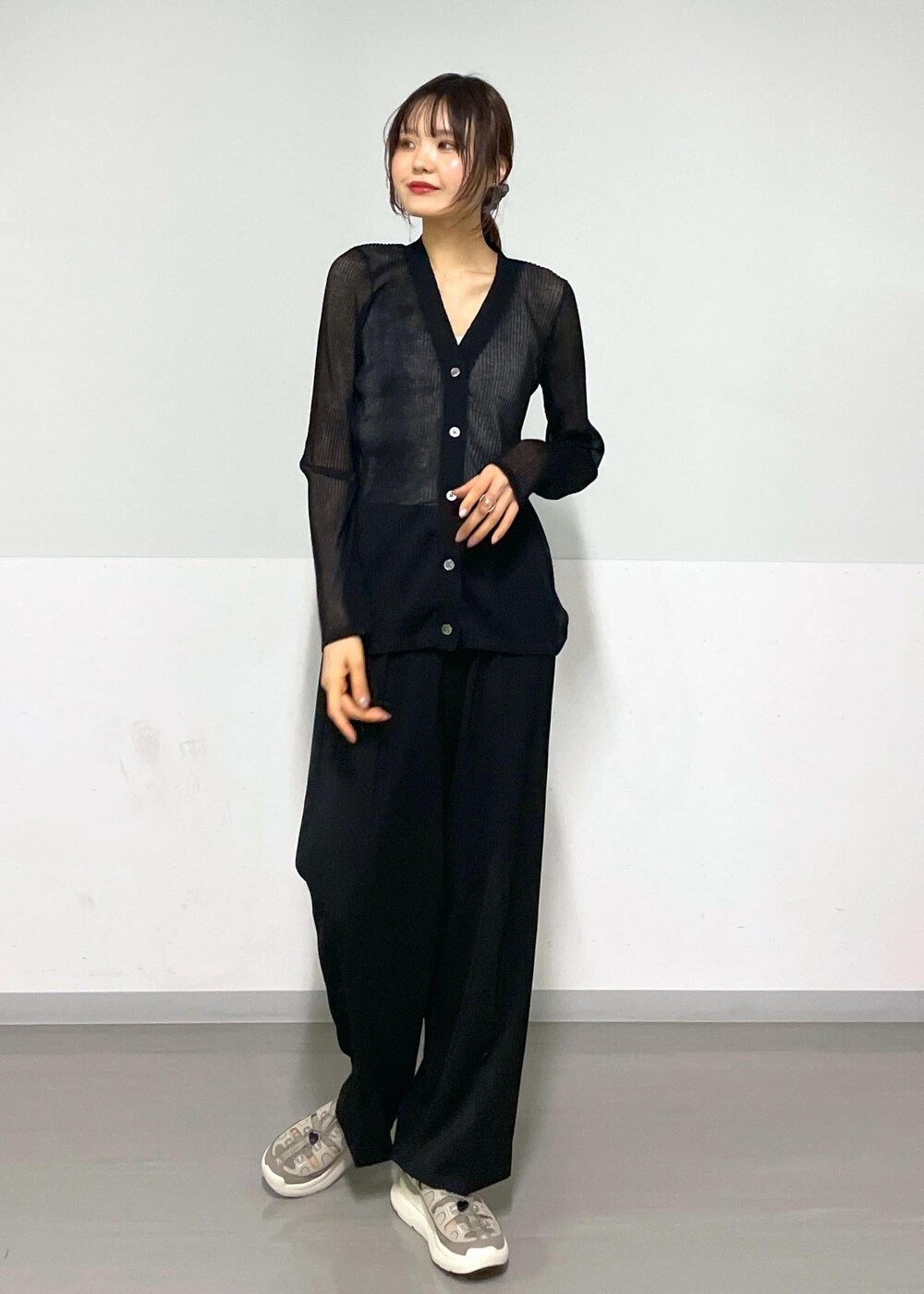 グレー系のタンクトップ、ブラック系のボディバッグ/ウエストポーチ、ブラック系のカーディガン/ボレロを着用したレディースの春コーディネートの2枚目の写真