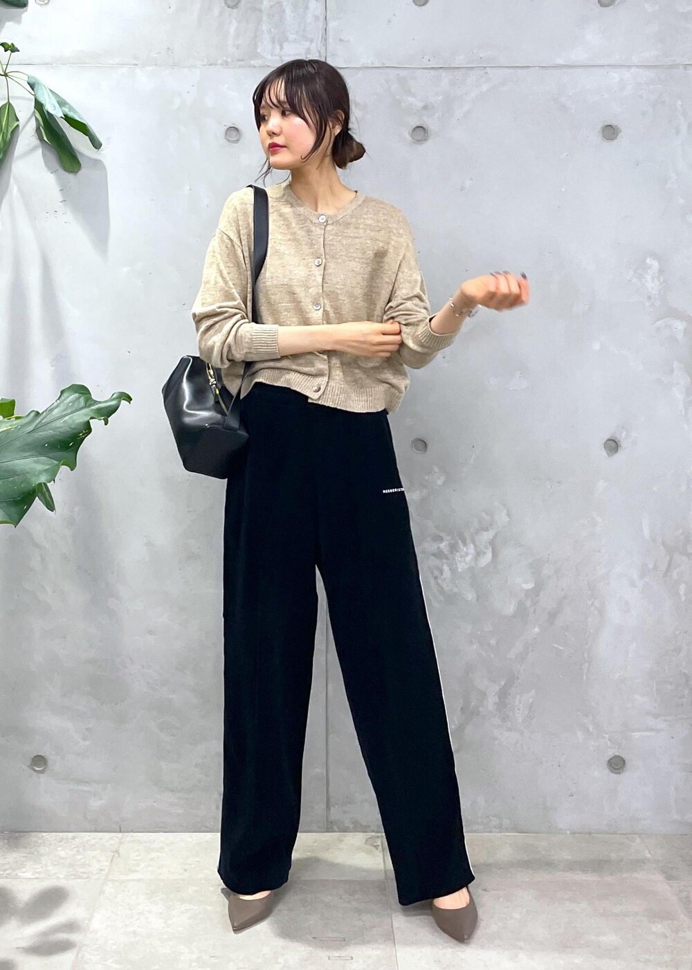ブラック系のショルダーバッグ、ブラック系のその他パンツ、ベージュ系のカーディガン/ボレロを着用したレディースの冬コーディネートの3枚目の写真