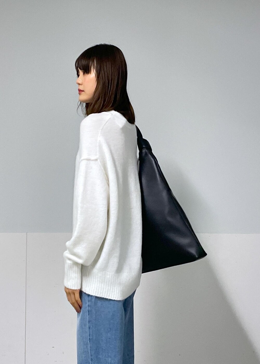 ブラック系のバレエシューズ、ブルー系のデニムパンツ、ホワイト系のニット/セーターを着用したレディースの秋コーディネートの7枚目の写真