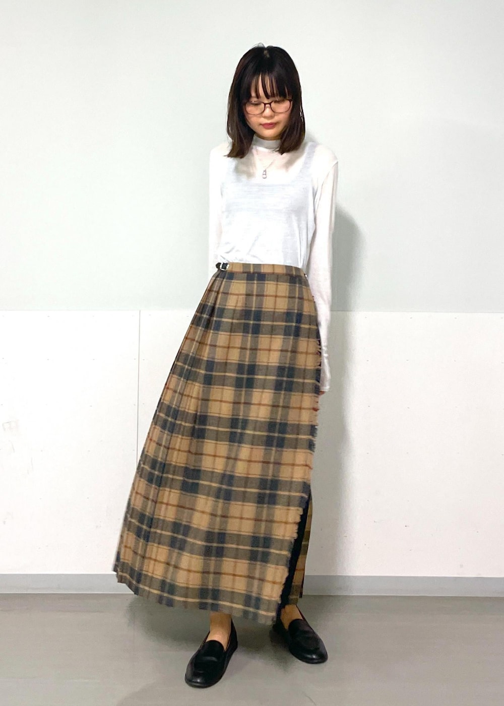 イエロー系のショルダーバッグ、ホワイト系のTシャツ/カットソー、ベージュ系のスカートを着用したレディースの秋コーディネートの8枚目の写真