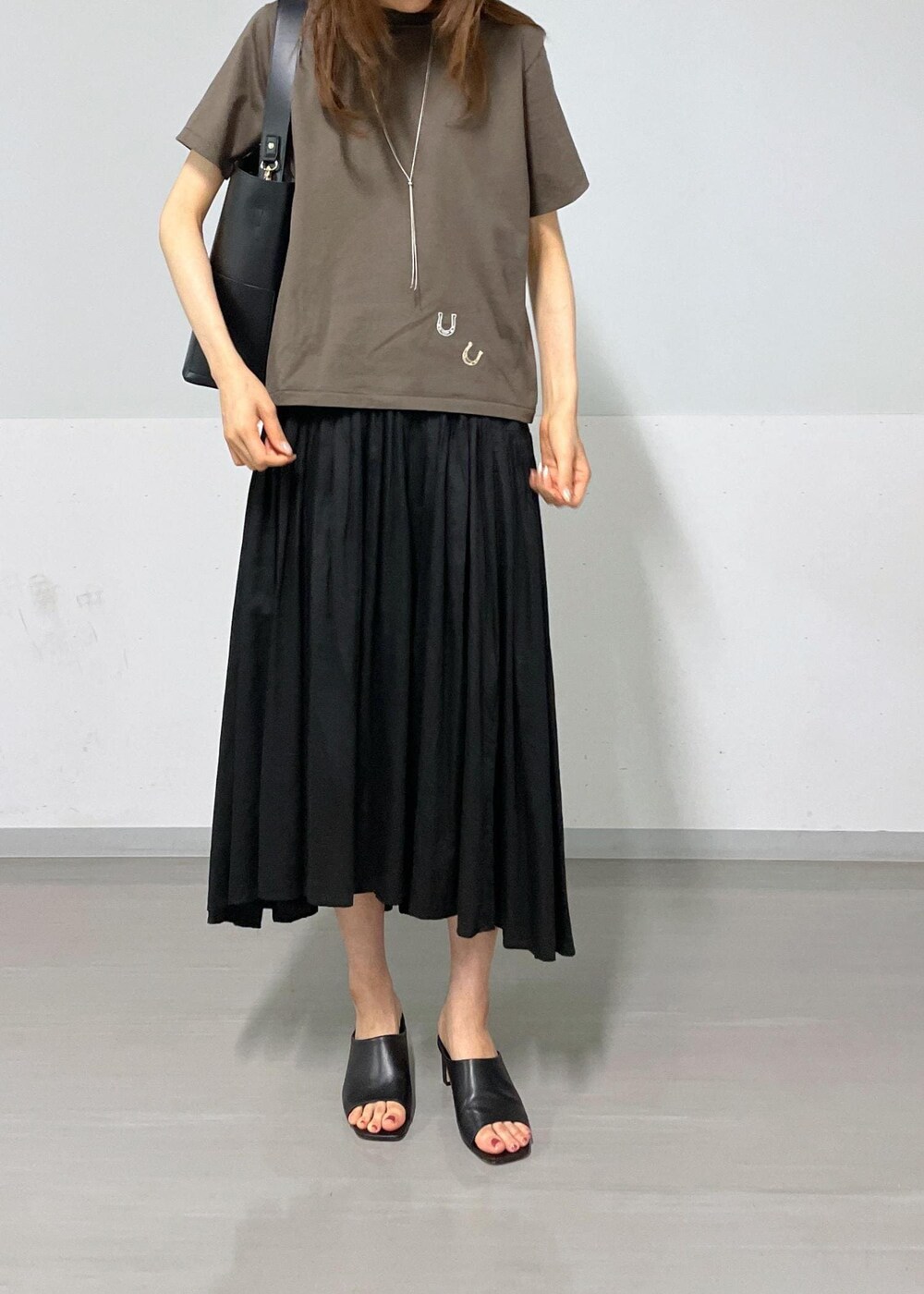 ブラック系のトートバッグ、ブラック系のサンダル、ブラック系のスカートを着用したレディースの夏コーディネートの4枚目の写真