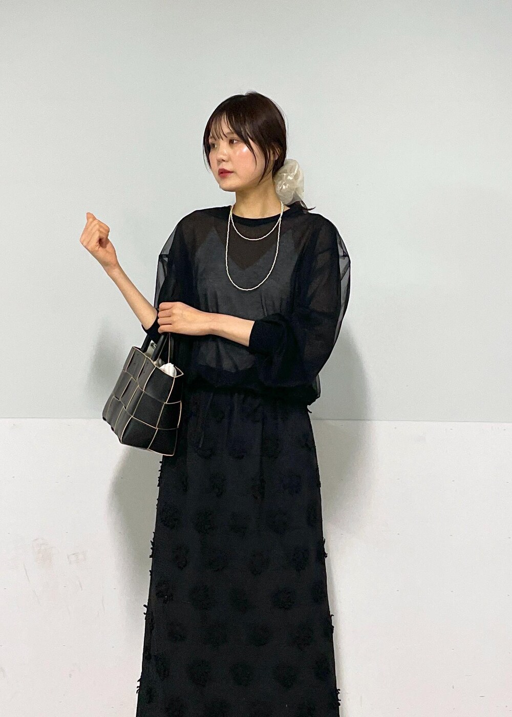 ブラック系のトートバッグ、ホワイト系のキャミソール、ブラック系のTシャツ/カットソーを着用したレディースの春コーディネートの2枚目の写真