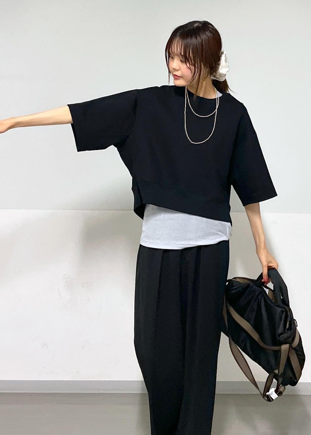 ブラック系のスラックス、シルバー系のサンダル、ブラック系のトートバッグを着用したレディースの夏コーディネートの6枚目の写真