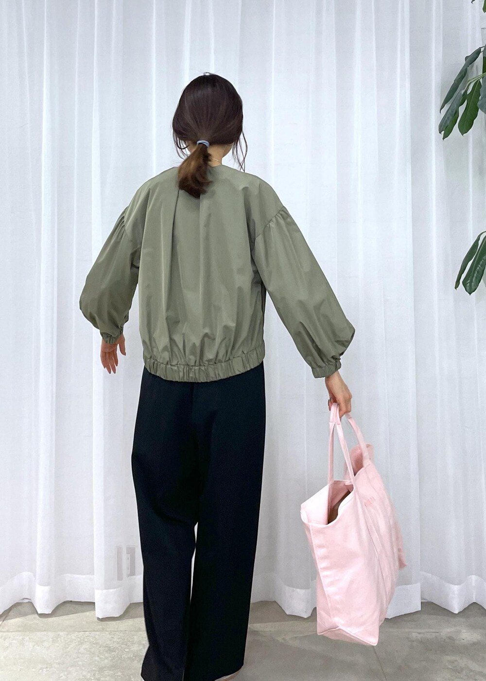 ブラック系のスラックス、グリーン系のブルゾン、シルバー系のパンプスを着用したレディースの冬コーディネートの5枚目の写真