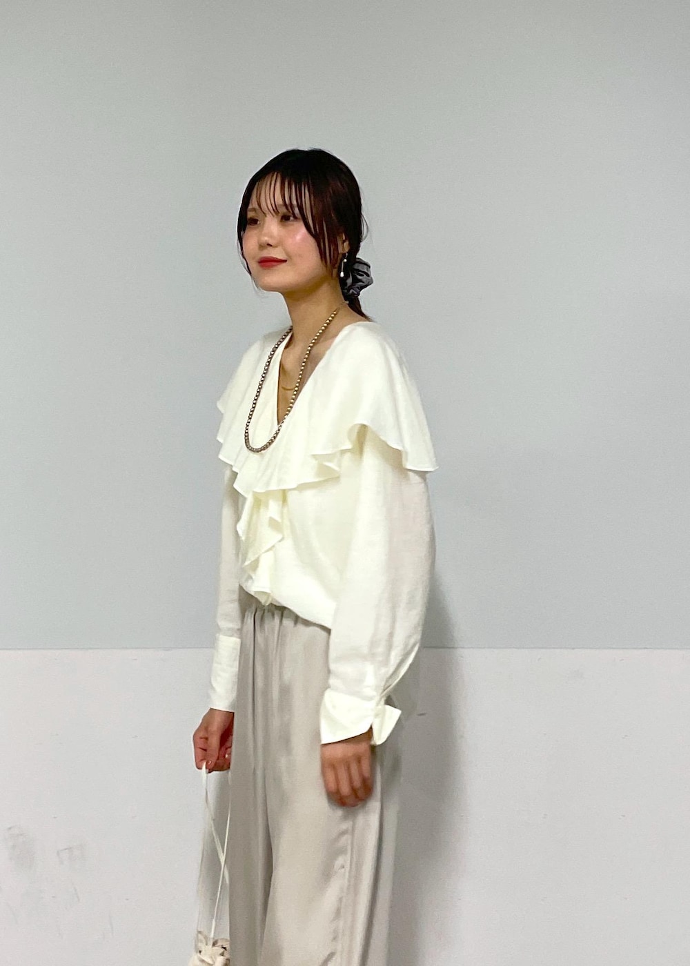 ホワイト系のシャツ/ブラウス、シルバー系のサンダル、ホワイト系のショルダーバッグを着用したレディースの夏コーディネートの6枚目の写真