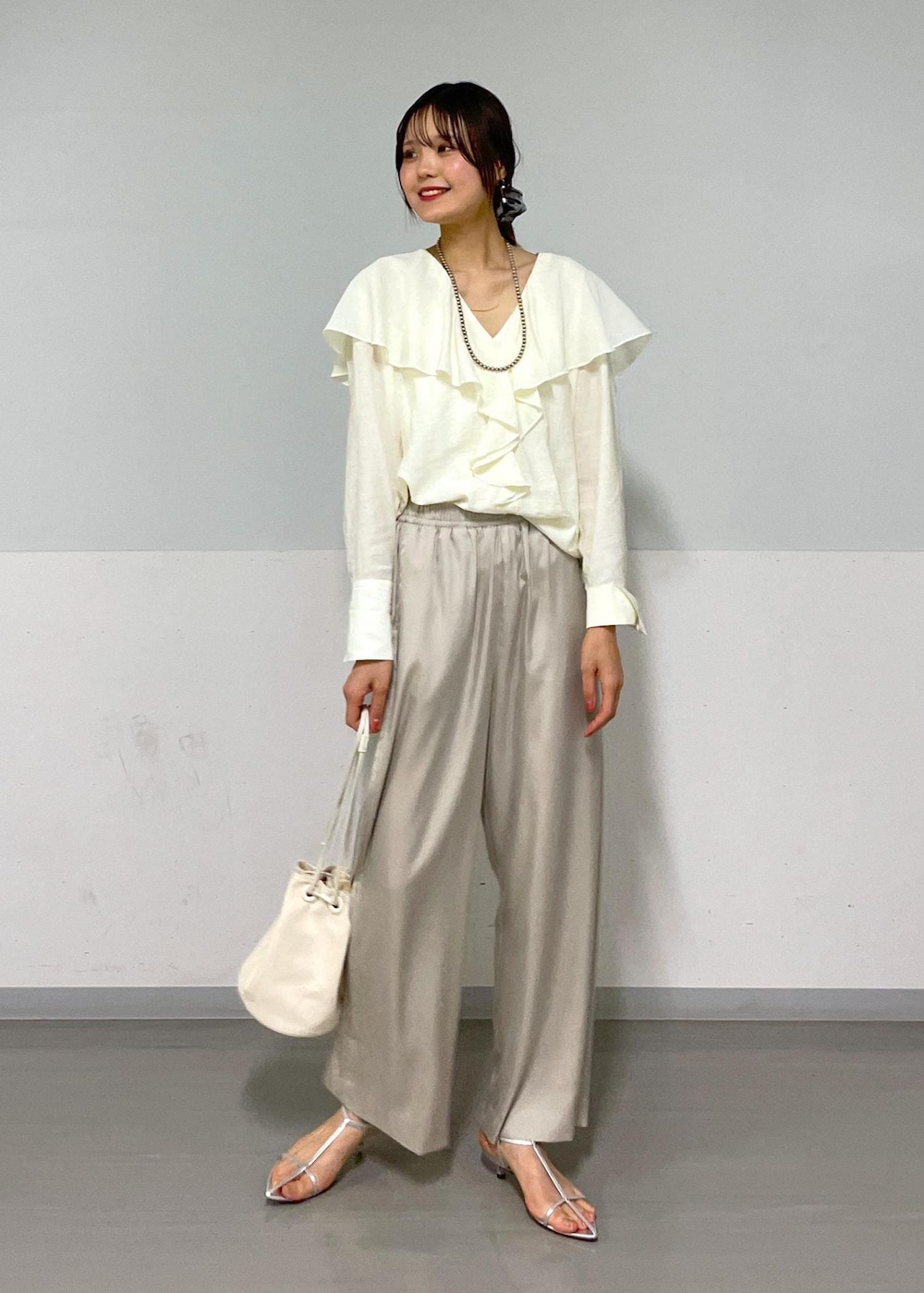 ホワイト系のシャツ/ブラウス、シルバー系のサンダル、ホワイト系のショルダーバッグを着用したレディースの夏コーディネートの2枚目の写真