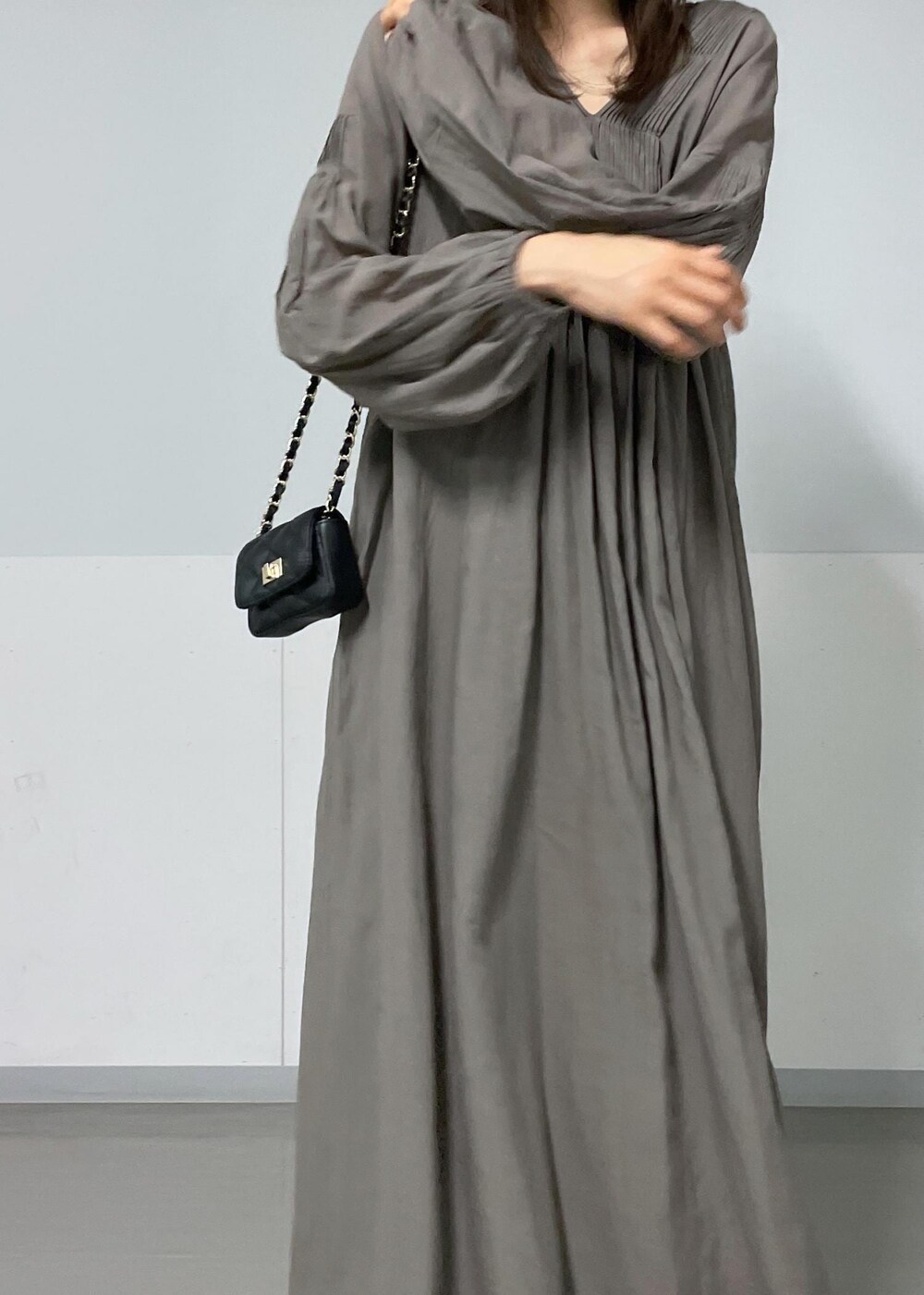 ブラック系のショルダーバッグ、グリーン系のタンクトップ、グレー系のワンピースを着用したレディースの夏コーディネートの7枚目の写真