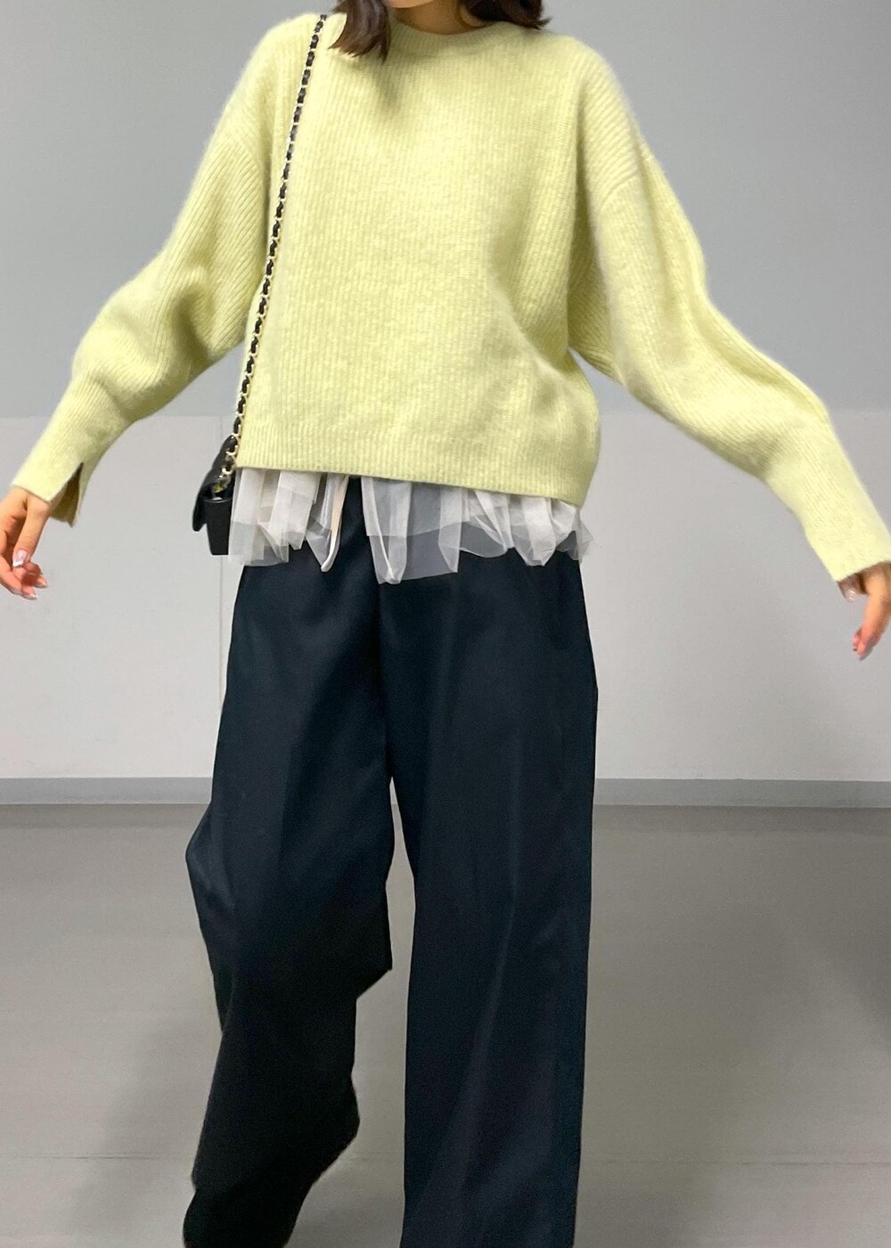 ブラック系のショルダーバッグ、ブラック系のその他パンツ、イエロー系のニット/セーターを着用したレディースの秋コーディネートの5枚目の写真