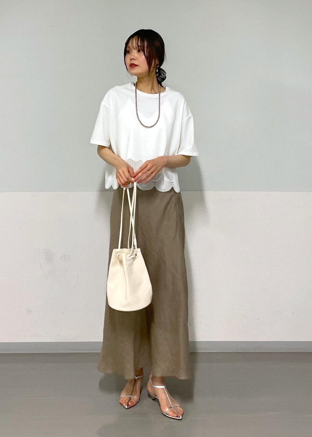 ホワイト系のキャミソール、シルバー系のサンダル、グリーン系のスカートを着用したレディースの夏コーディネートの10枚目の写真