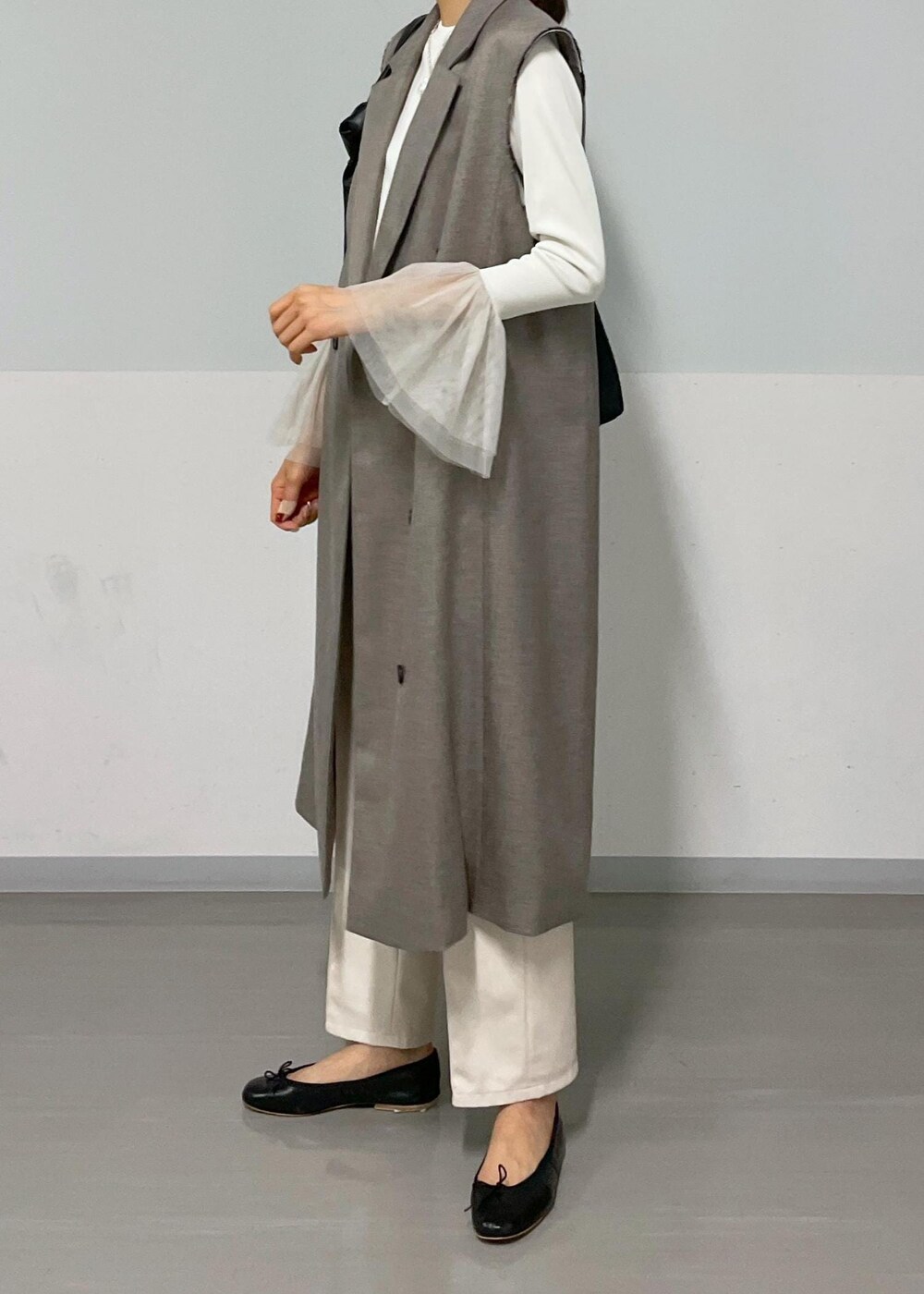 ベージュ系のジャンパースカート、ホワイト系のTシャツ/カットソー、ブラック系のバレエシューズを着用したレディースの秋コーディネートの3枚目の写真