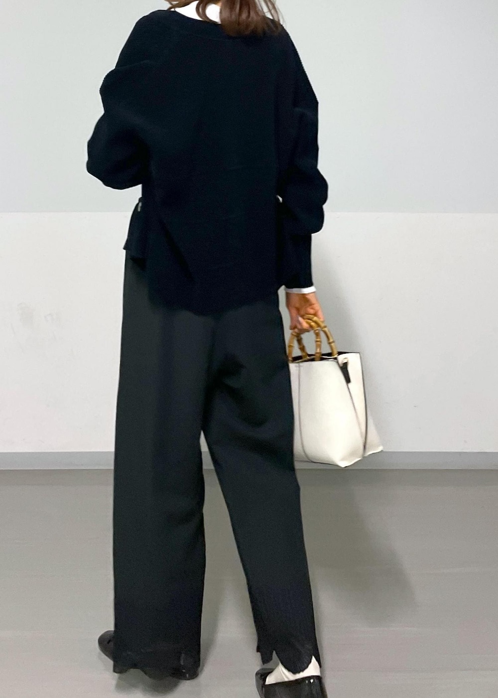 ブラック系のカーディガン/ボレロ、ホワイト系のTシャツ/カットソー、ホワイト系のハンドバッグを着用したレディースの冬コーディネートの2枚目の写真