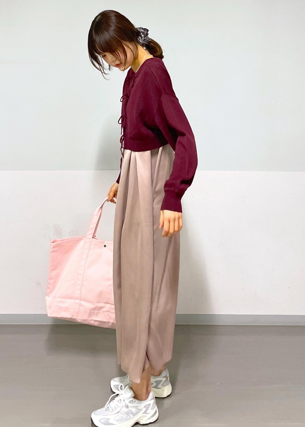 レッド系のニット/セーター、イエロー系のワンピース、ホワイト系のスニーカーを着用したレディースの春コーディネートの6枚目の写真