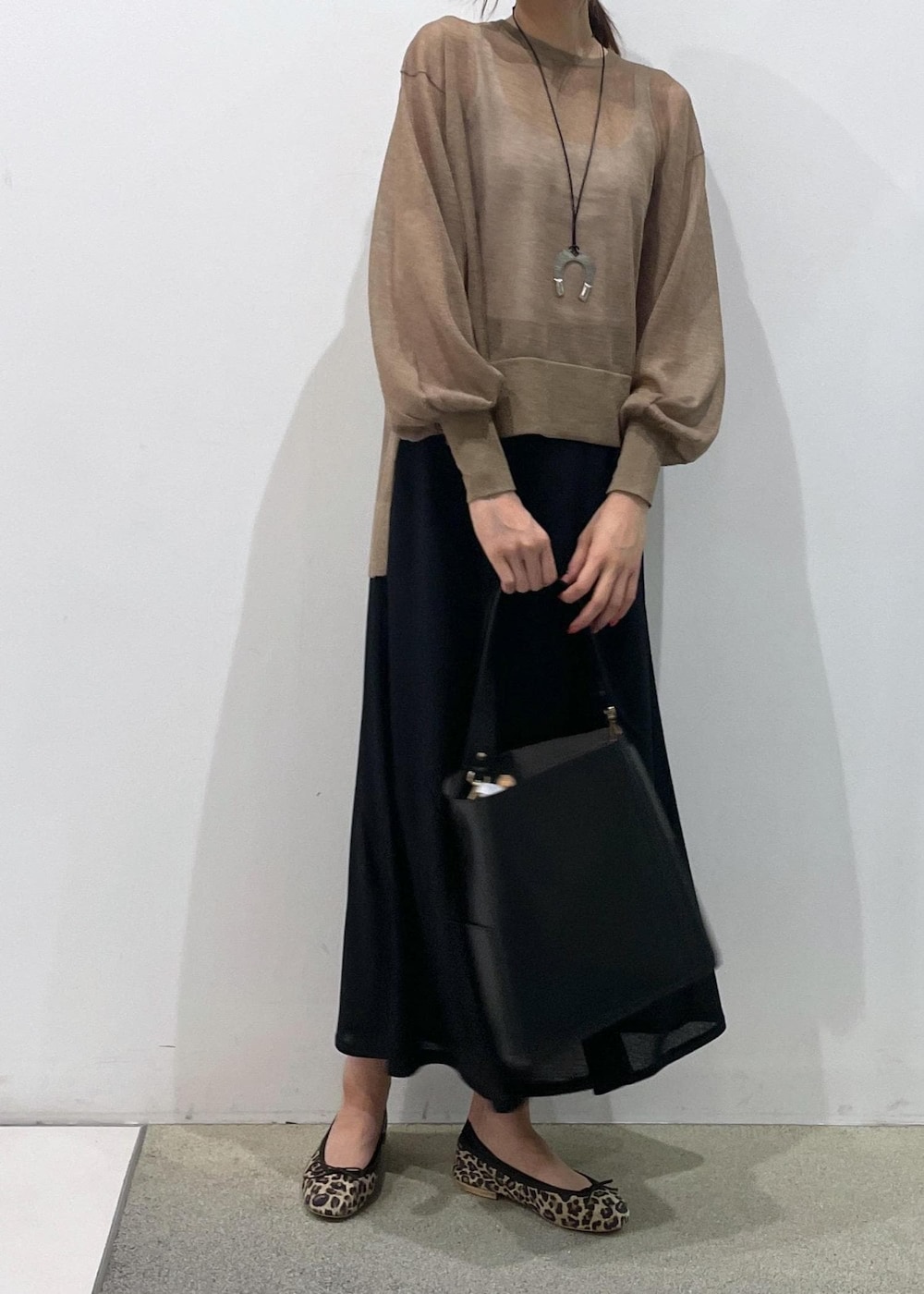 ブラック系のスカート、ゴールド系のTシャツ/カットソー、ブラック系のトートバッグを着用したレディースの夏コーディネートの6枚目の写真