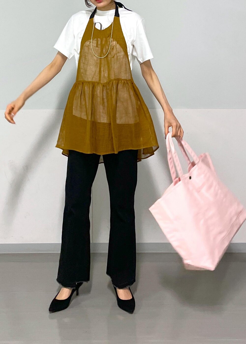 グレー系のデニムパンツ、ホワイト系のTシャツ/カットソー、ブラウン系のベストを着用したレディースの春コーディネートの8枚目の写真