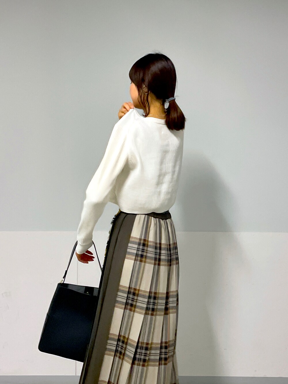 ホワイト系のカーディガン/ボレロ、イエロー系のスカート、ベージュ系のスニーカーを着用したレディースの秋コーディネートの4枚目の写真