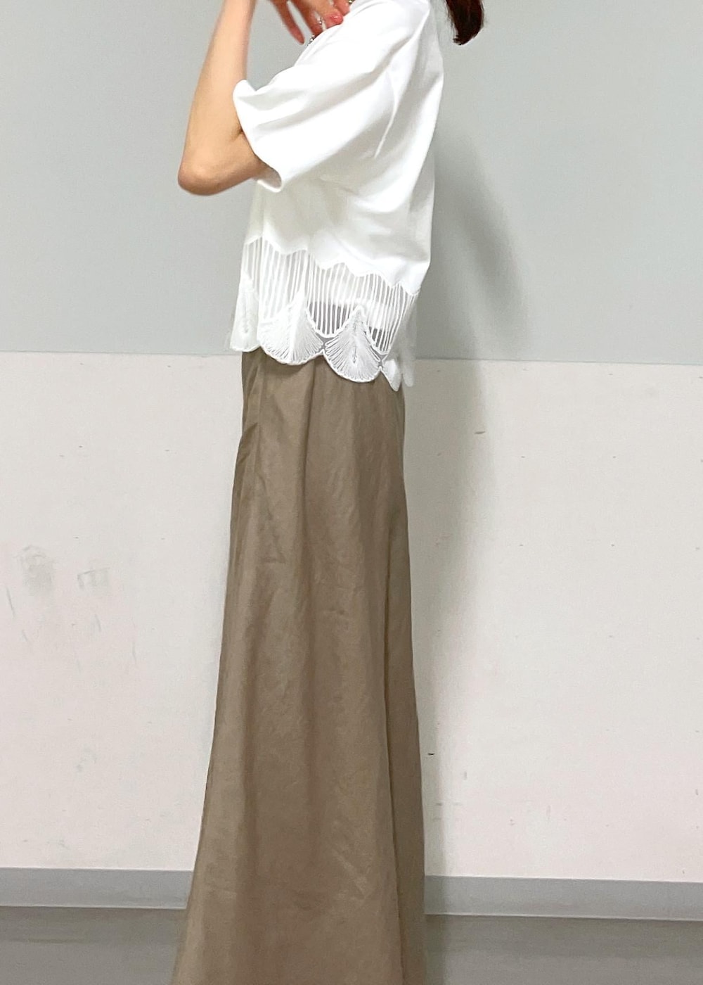 ホワイト系のキャミソール、シルバー系のサンダル、グリーン系のスカートを着用したレディースの夏コーディネートの8枚目の写真