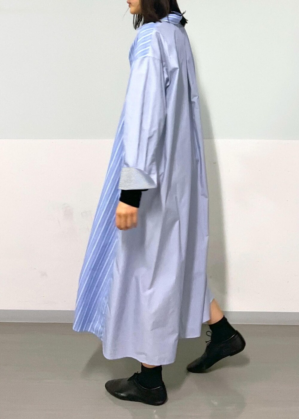 ブラック系のショルダーバッグ、ブルー系のシャツワンピース、ホワイト系のネックレスを着用したレディースの秋コーディネートの9枚目の写真