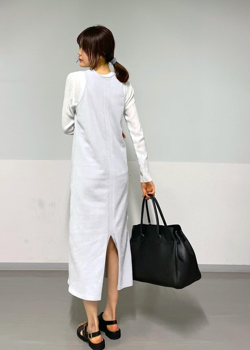 ブラック系のサンダル、グレー系のワンピース、ホワイト系のTシャツ/カットソーを着用したレディースの冬コーディネートの10枚目の写真