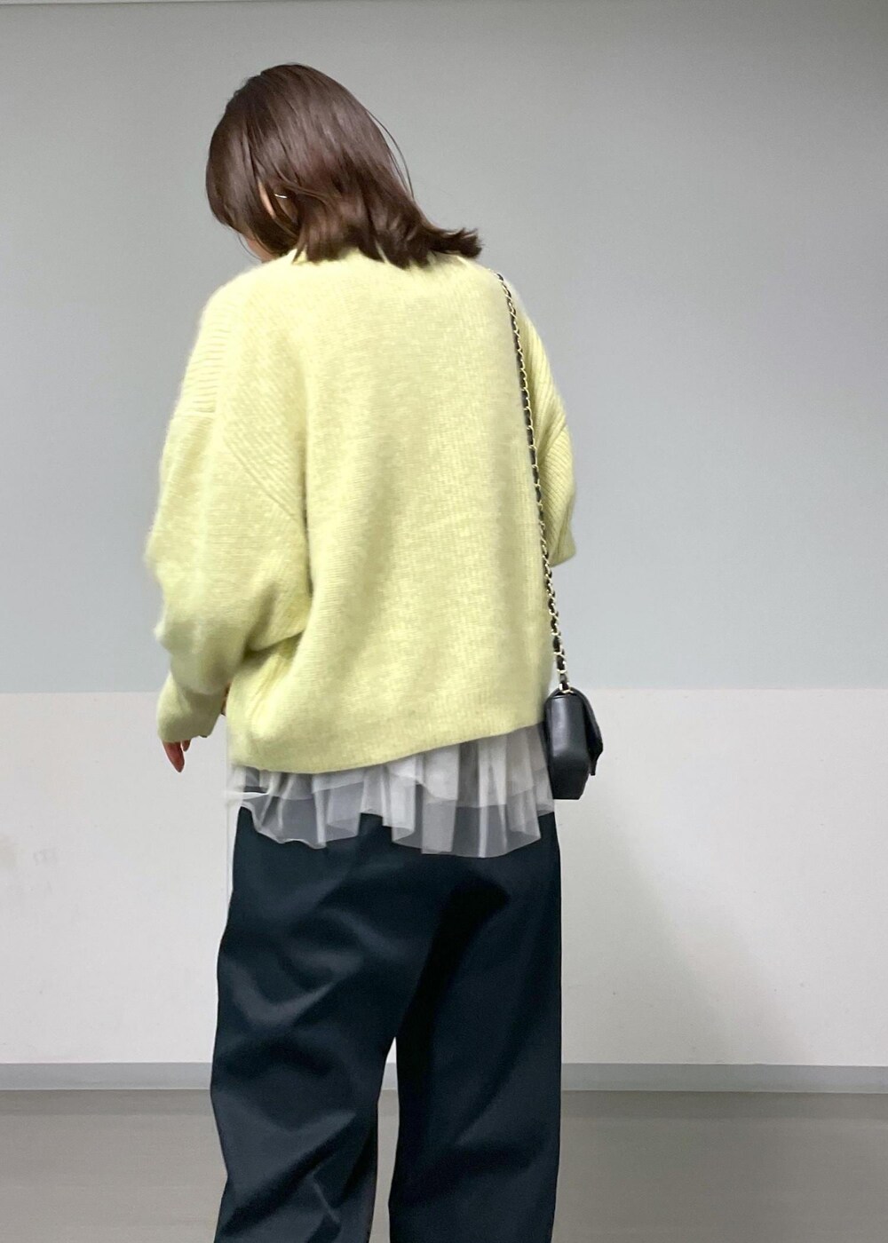 ブラック系のショルダーバッグ、ブラック系のその他パンツ、イエロー系のニット/セーターを着用したレディースの秋コーディネートの7枚目の写真