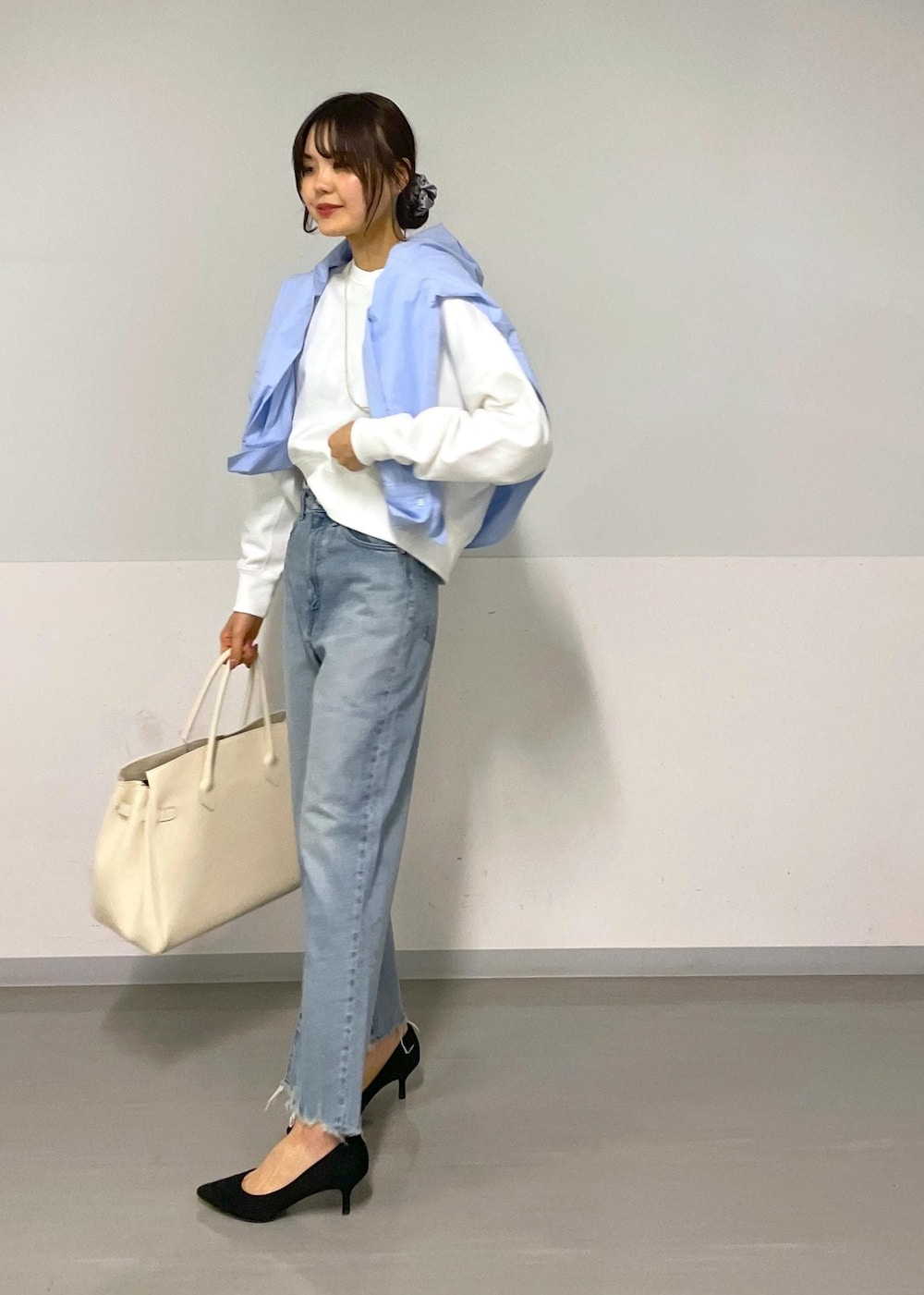 ブルー系のシャツ/ブラウス、ホワイト系のスウェット、ブルー系のデニムパンツを着用したレディースの冬コーディネートの4枚目の写真