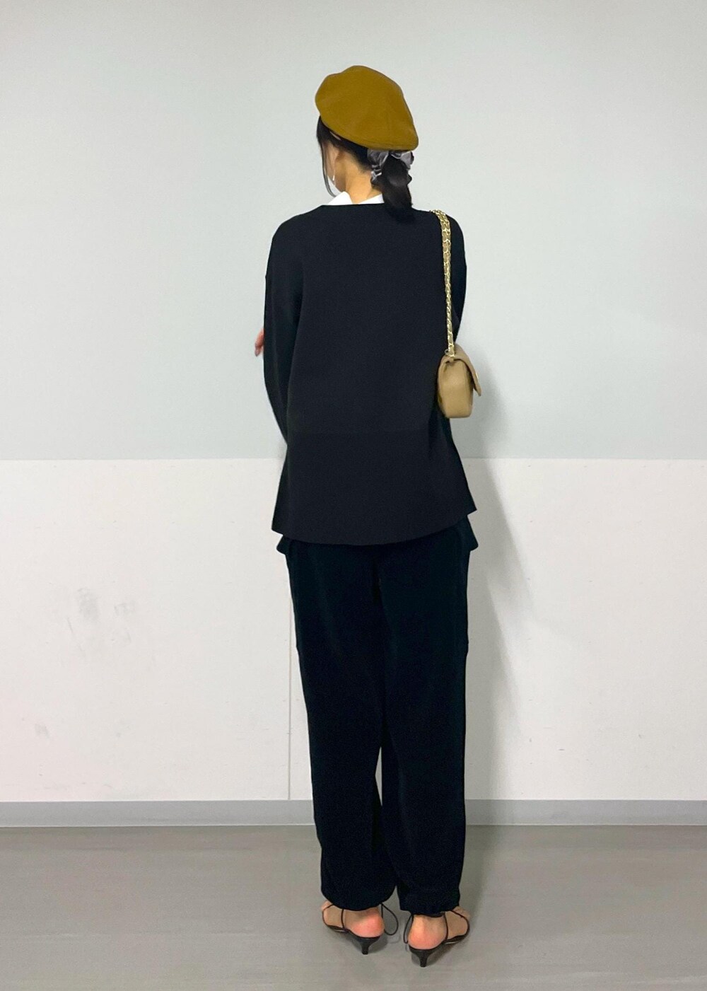 ベージュ系のショルダーバッグ、ブラック系のサンダル、ブラック系のカーゴパンツを着用したレディースの秋コーディネートの5枚目の写真