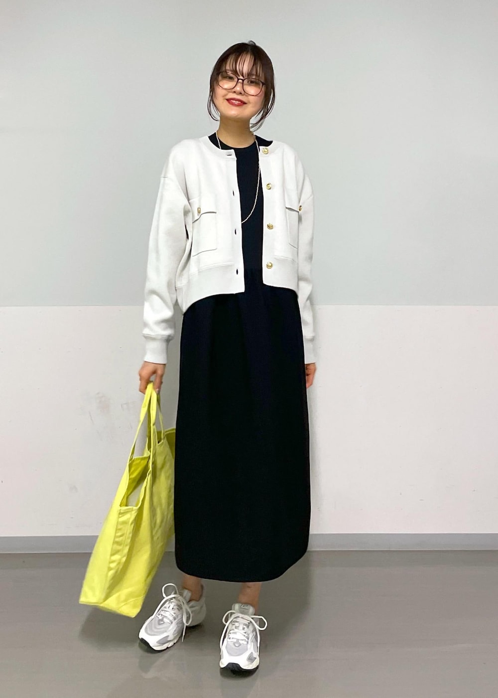 ブラック系のワンピース、ホワイト系のスニーカーを着用したレディースの春コーディネートの5枚目の写真