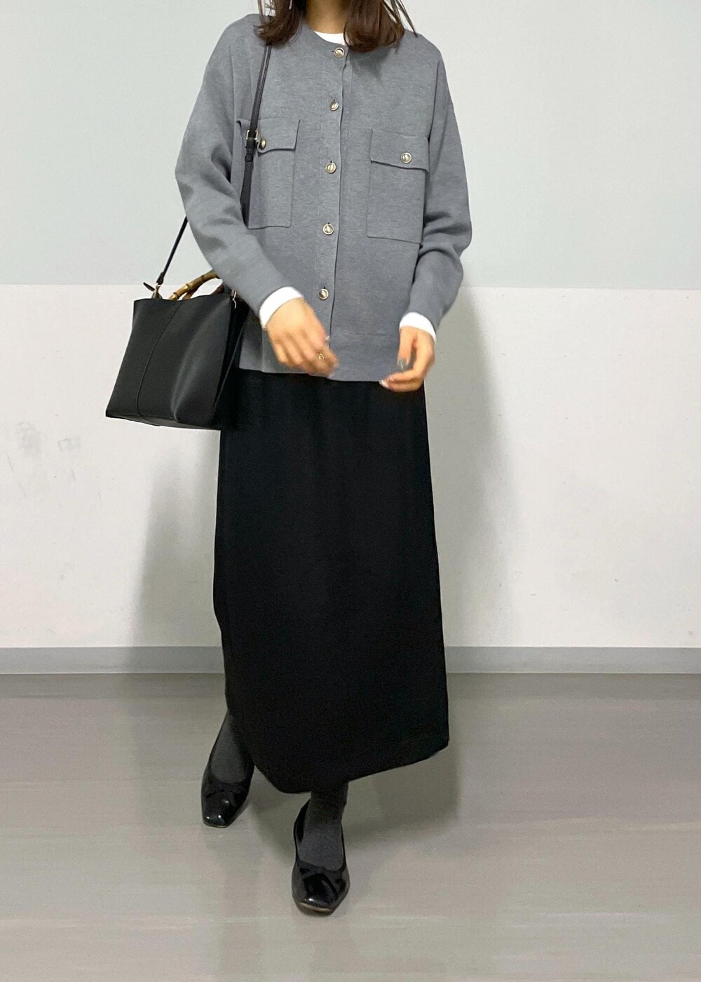 グレー系のカーディガン/ボレロ、ホワイト系のTシャツ/カットソー、ブラック系のハンドバッグを着用したレディースの冬コーディネートの7枚目の写真