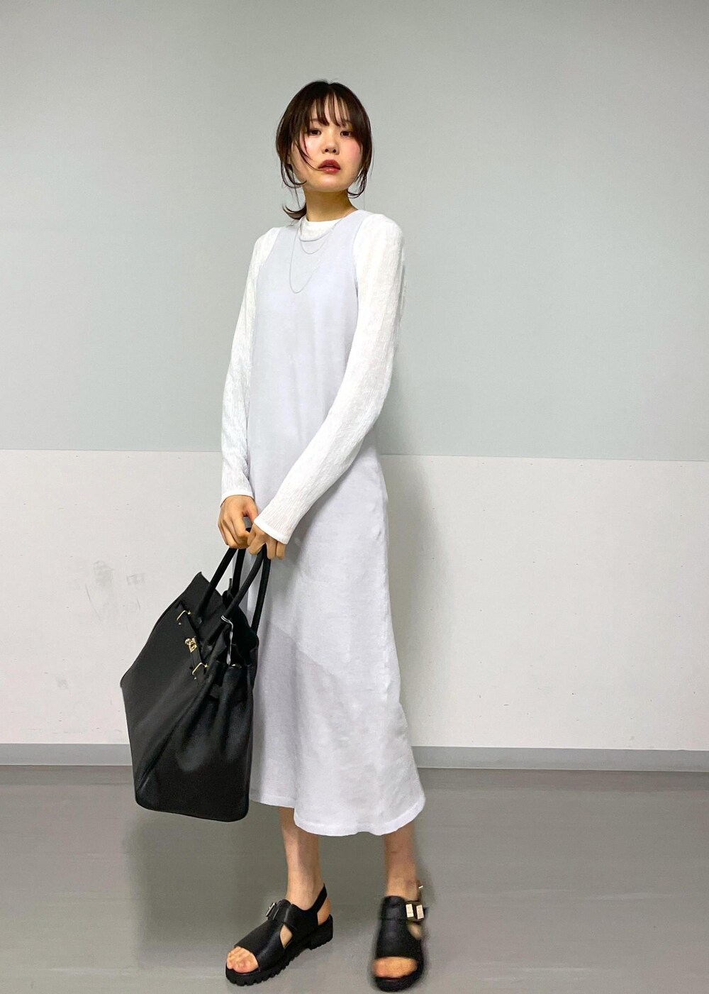 ブラック系のサンダル、グレー系のワンピース、ホワイト系のTシャツ/カットソーを着用したレディースの冬コーディネートの8枚目の写真