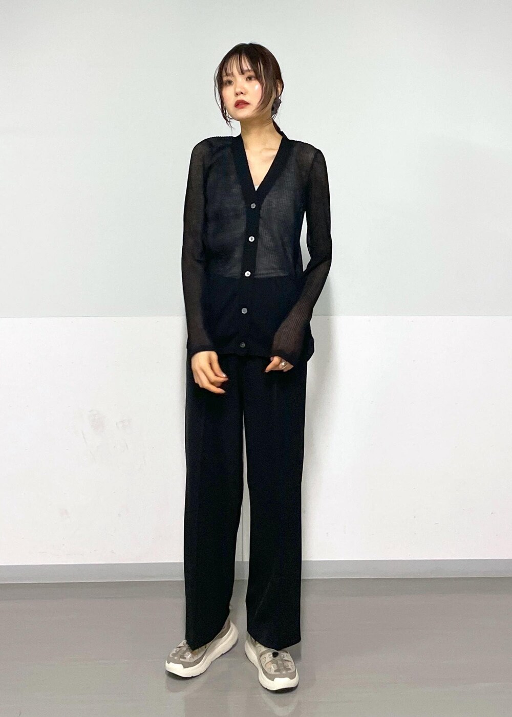 グレー系のタンクトップ、ブラック系のボディバッグ/ウエストポーチ、ブラック系のカーディガン/ボレロを着用したレディースの春コーディネートの6枚目の写真