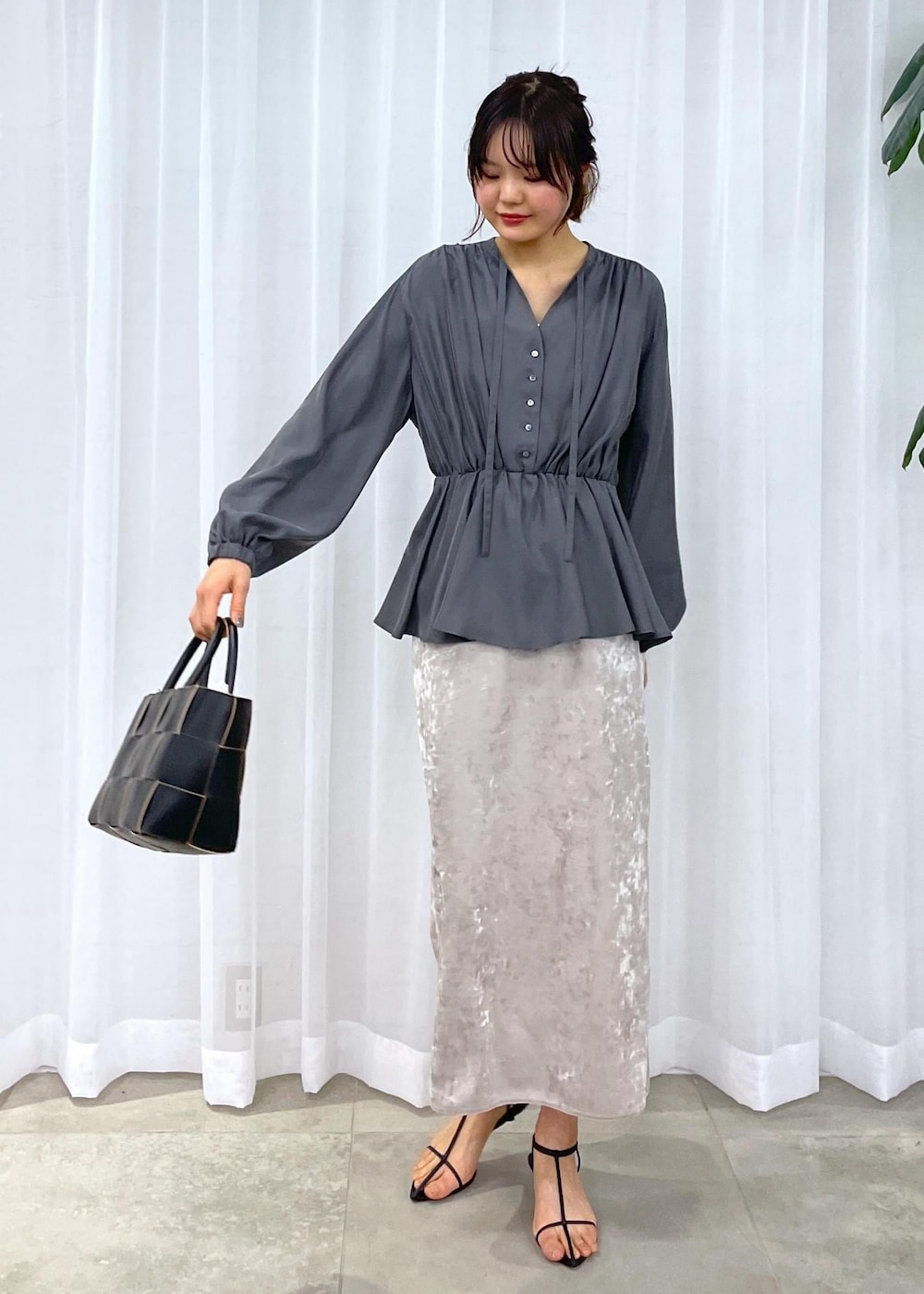 ブラック系のトートバッグ、ベージュ系のスカート、グレー系のシャツ/ブラウスを着用したレディースの冬コーディネートの3枚目の写真