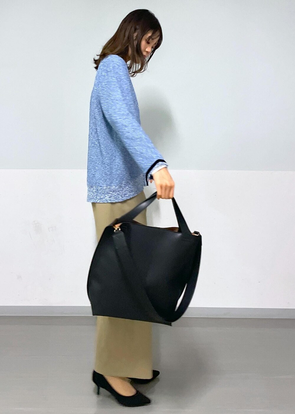 ブラック系のトートバッグ、ベージュ系のその他パンツ、ホワイト系のTシャツ/カットソーを着用したレディースの冬コーディネートの2枚目の写真