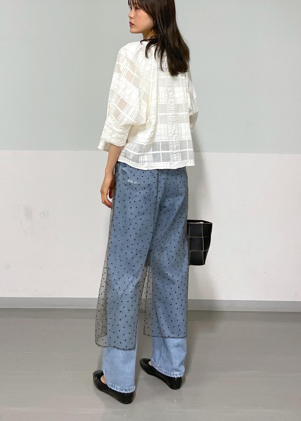 ブラック系のトートバッグ、ホワイト系のタンクトップ、グレー系のスカートを着用したレディースの夏コーディネートの3枚目の写真