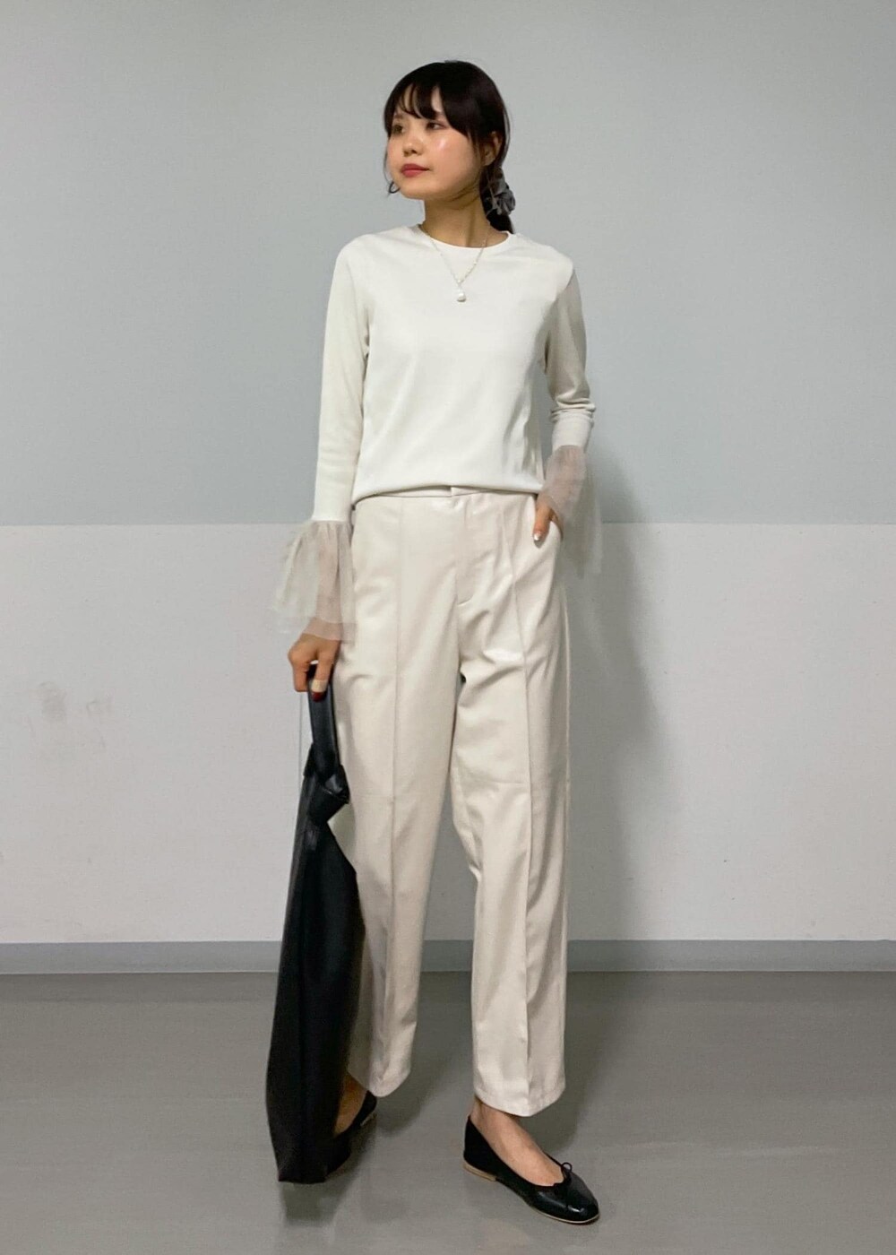 ベージュ系のジャンパースカート、ホワイト系のTシャツ/カットソー、ブラック系のバレエシューズを着用したレディースの秋コーディネートの6枚目の写真