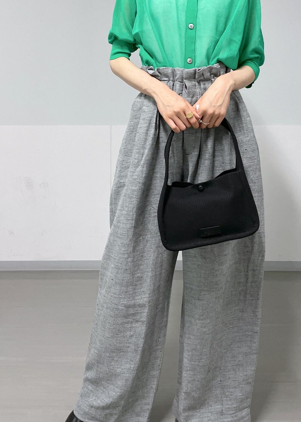 グレー系のタンクトップ、ブラック系のサンダル、グレー系のスラックスを着用したレディースの春コーディネートの5枚目の写真