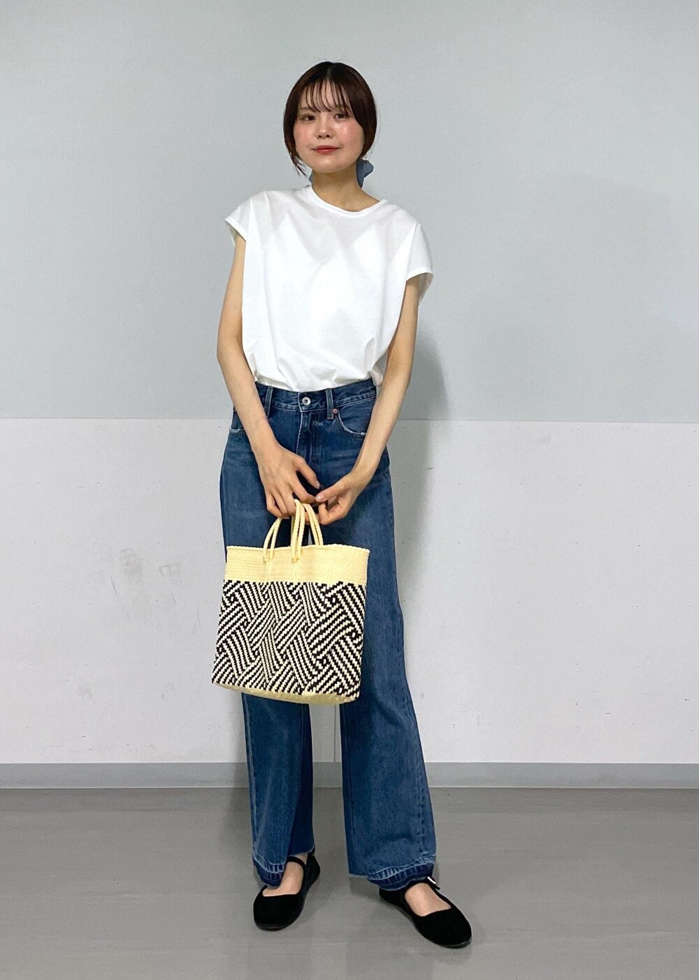 ホワイト系のかごバッグ、グレー系のカーディガン/ボレロ、ホワイト系のTシャツ/カットソーを着用したレディースの春コーディネートの3枚目の写真