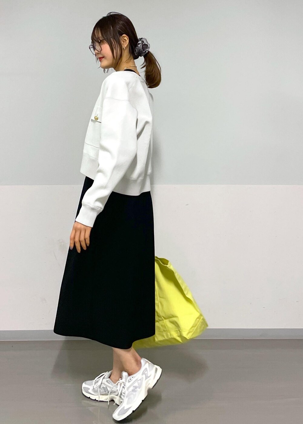 ブラック系のワンピース、ホワイト系のスニーカーを着用したレディースの春コーディネートの2枚目の写真