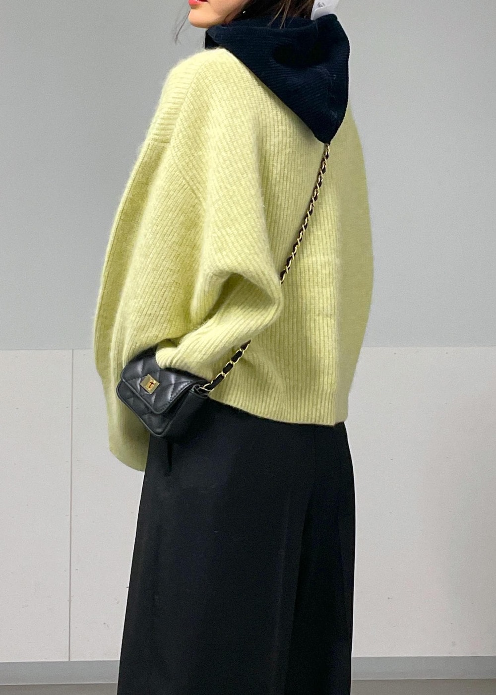 ブラック系のショルダーバッグ、イエロー系のニット/セーター、ホワイト系のTシャツ/カットソーを着用したレディースの秋コーディネートの9枚目の写真