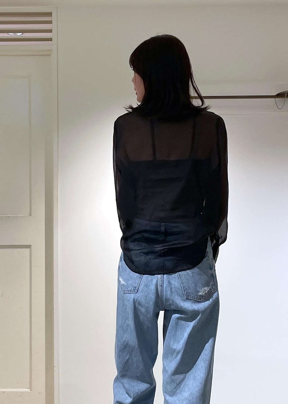 グレー系のノーカラージャケット、ブルー系のデニムパンツ、ブラック系のボストンバッグを着用したレディースの夏コーディネートの9枚目の写真