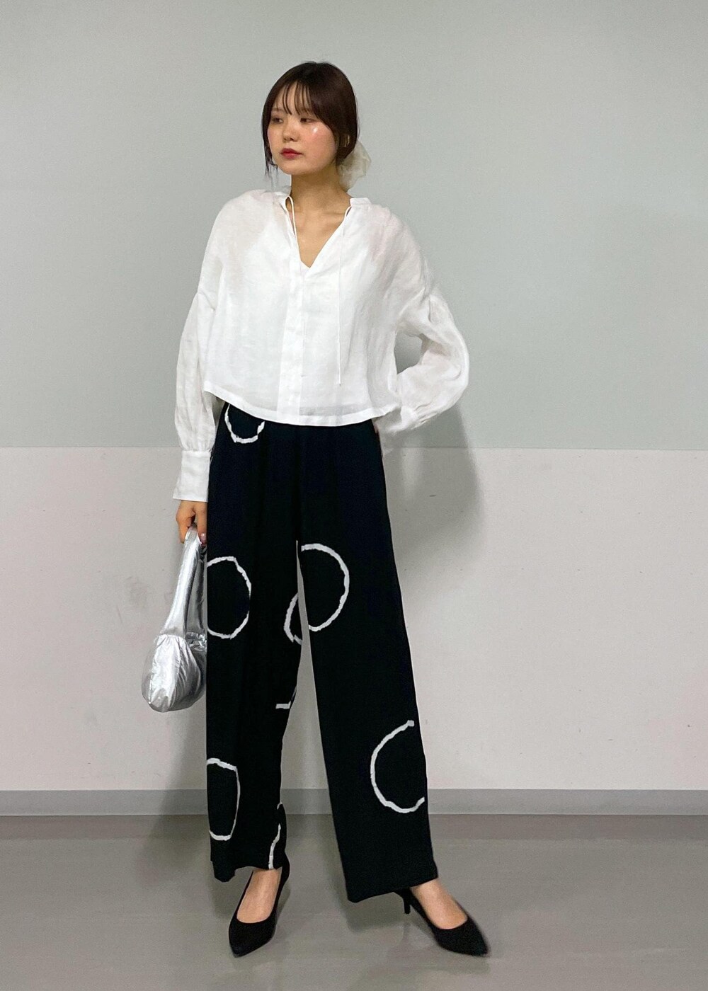 ホワイト系のシャツ/ブラウス、シルバー系のハンドバッグを着用したレディースの春コーディネートの6枚目の写真