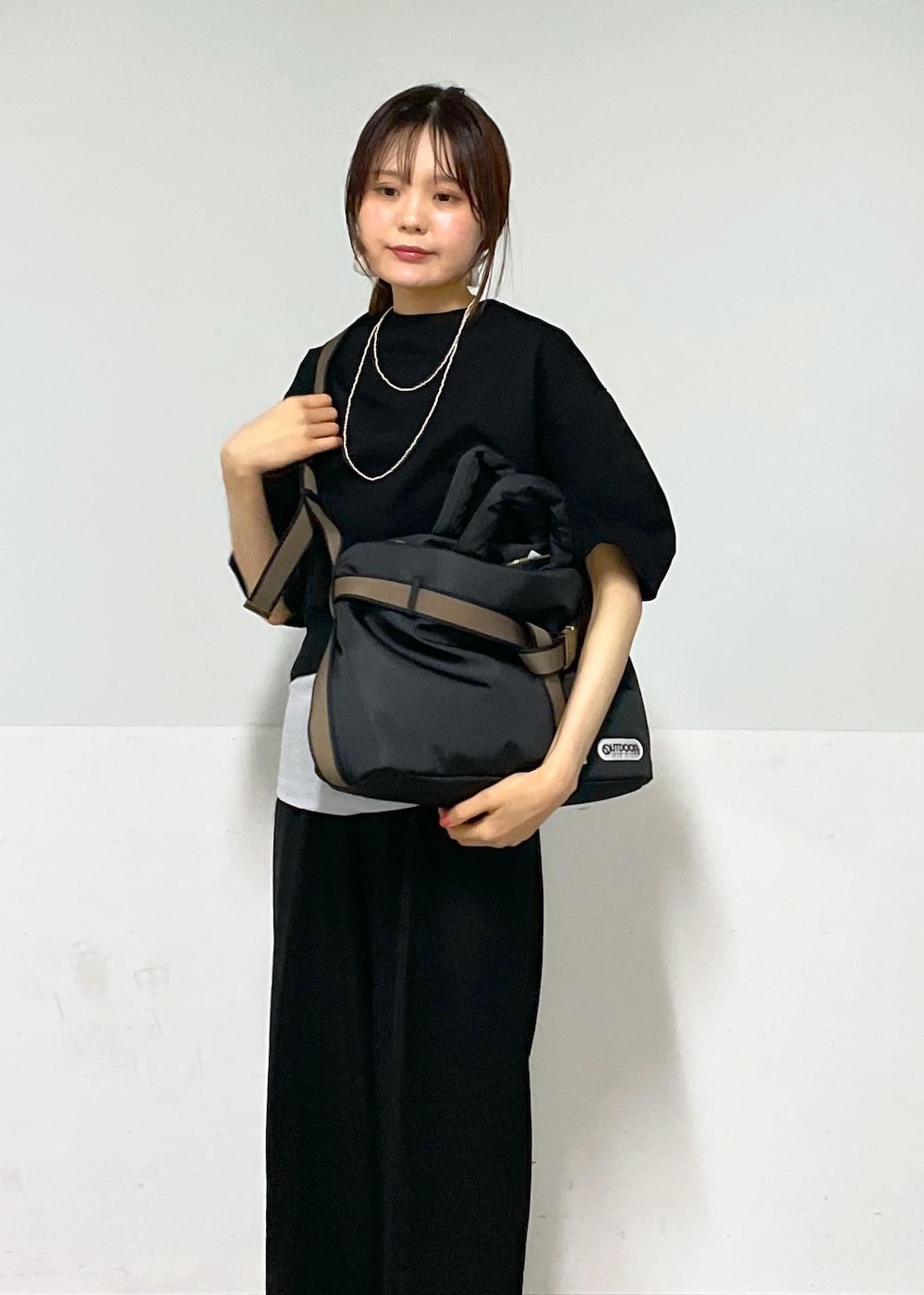 ブラック系のスラックス、シルバー系のサンダル、ブラック系のトートバッグを着用したレディースの夏コーディネートの9枚目の写真