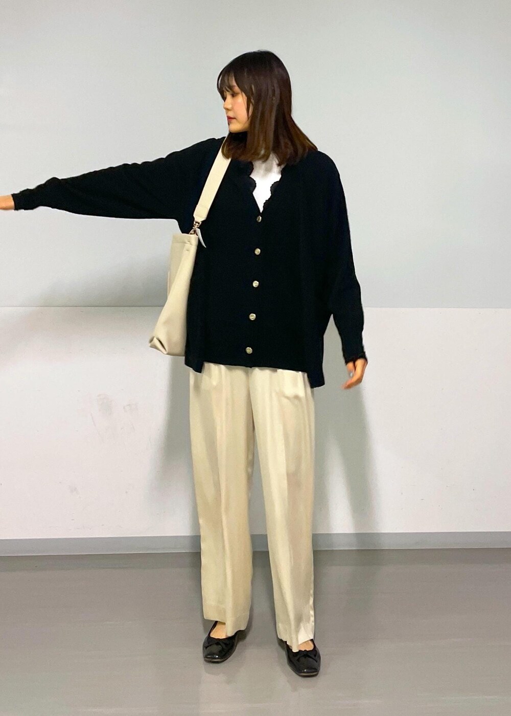 ベージュ系のその他パンツ、ブラック系のカーディガン/ボレロ、ベージュ系のトートバッグを着用したレディースの冬コーディネートの3枚目の写真