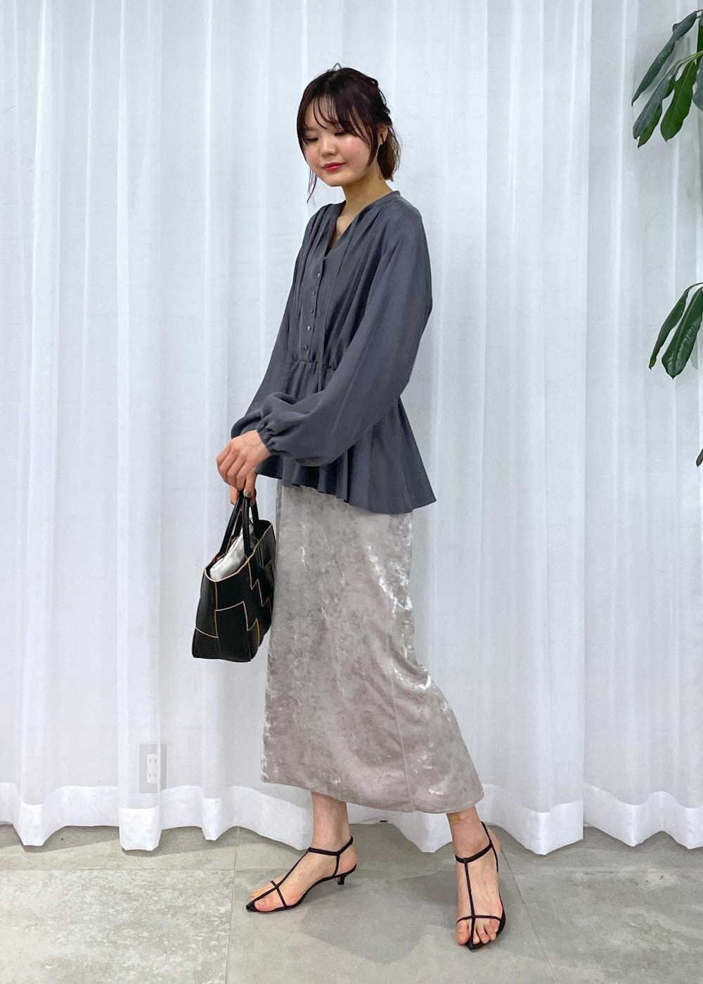 ブラック系のトートバッグ、ベージュ系のスカート、グレー系のシャツ/ブラウスを着用したレディースの冬コーディネートの5枚目の写真