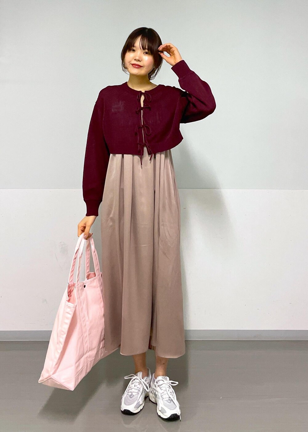 レッド系のニット/セーター、イエロー系のワンピース、ホワイト系のスニーカーを着用したレディースの春コーディネートの10枚目の写真