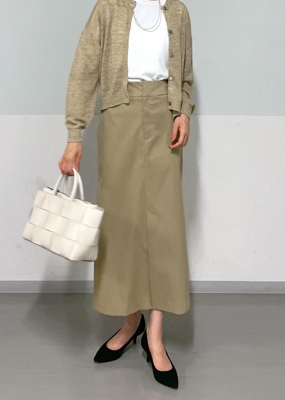 ホワイト系のトートバッグ、ベージュ系のスカート、ベージュ系のカーディガン/ボレロを着用したレディースの夏コーディネートの9枚目の写真