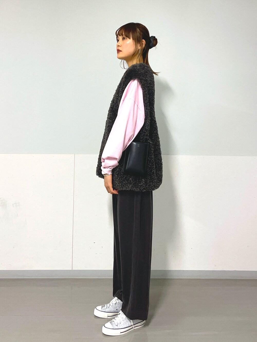 グレー系のベスト、グレー系のその他パンツ、シルバー系のスニーカーを着用したレディースの秋コーディネートの2枚目の写真