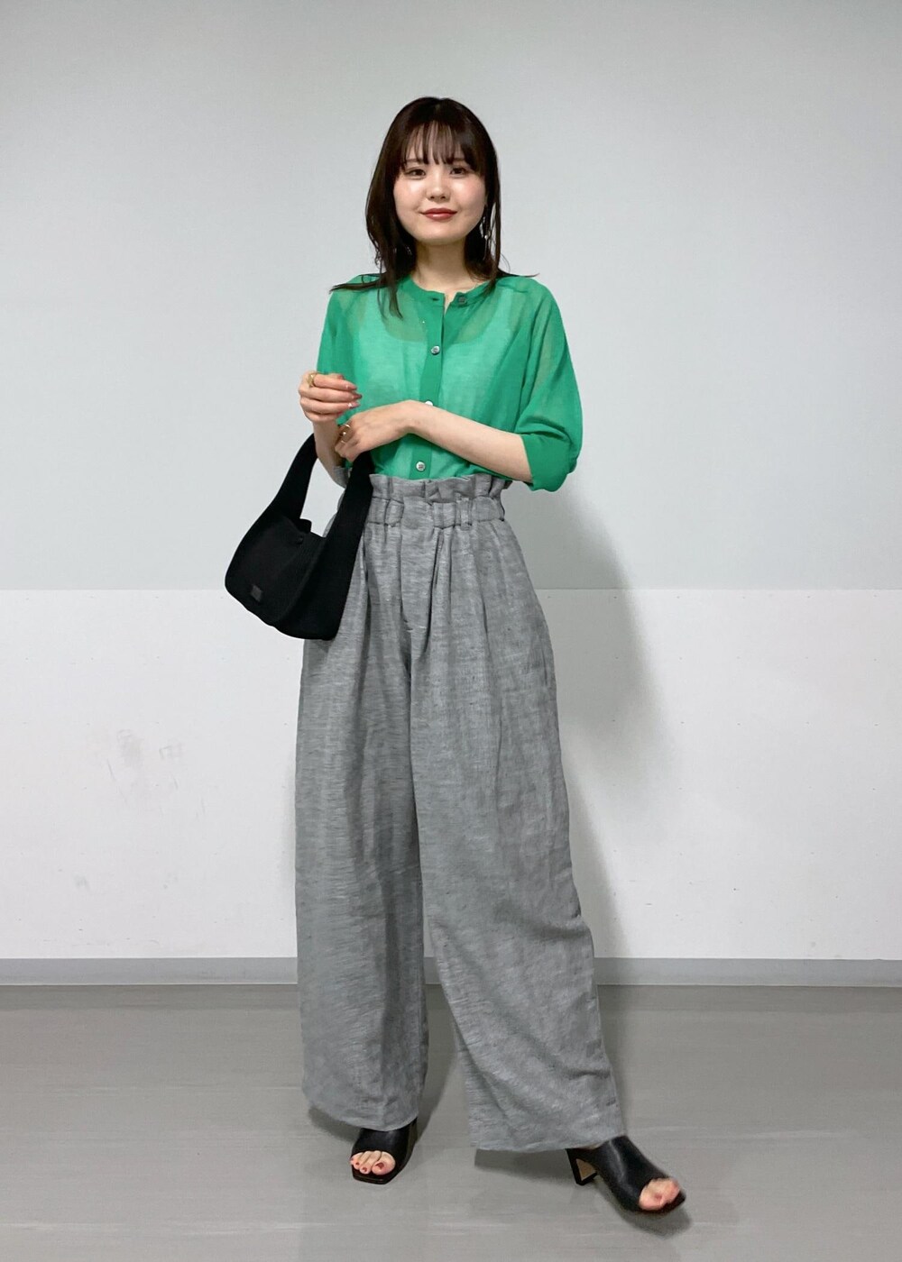 グレー系のタンクトップ、ブラック系のサンダル、グレー系のスラックスを着用したレディースの春コーディネートの4枚目の写真