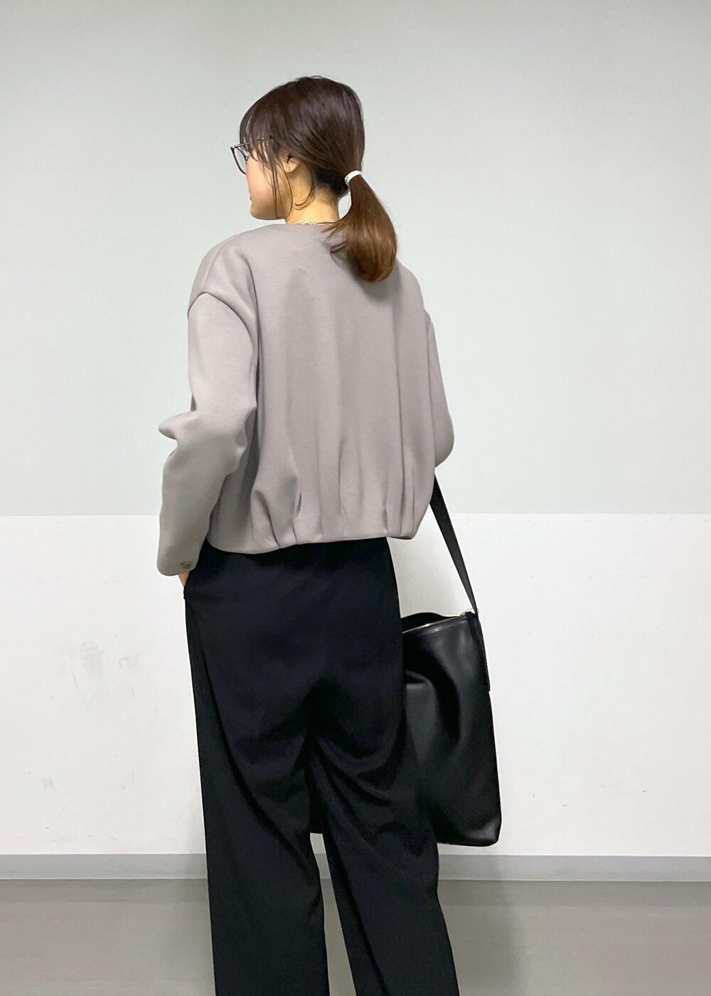 ブラック系のカーディガン/ボレロ、グレー系のTシャツ/カットソー、ブラック系のショルダーバッグを着用したレディースの春コーディネートの7枚目の写真