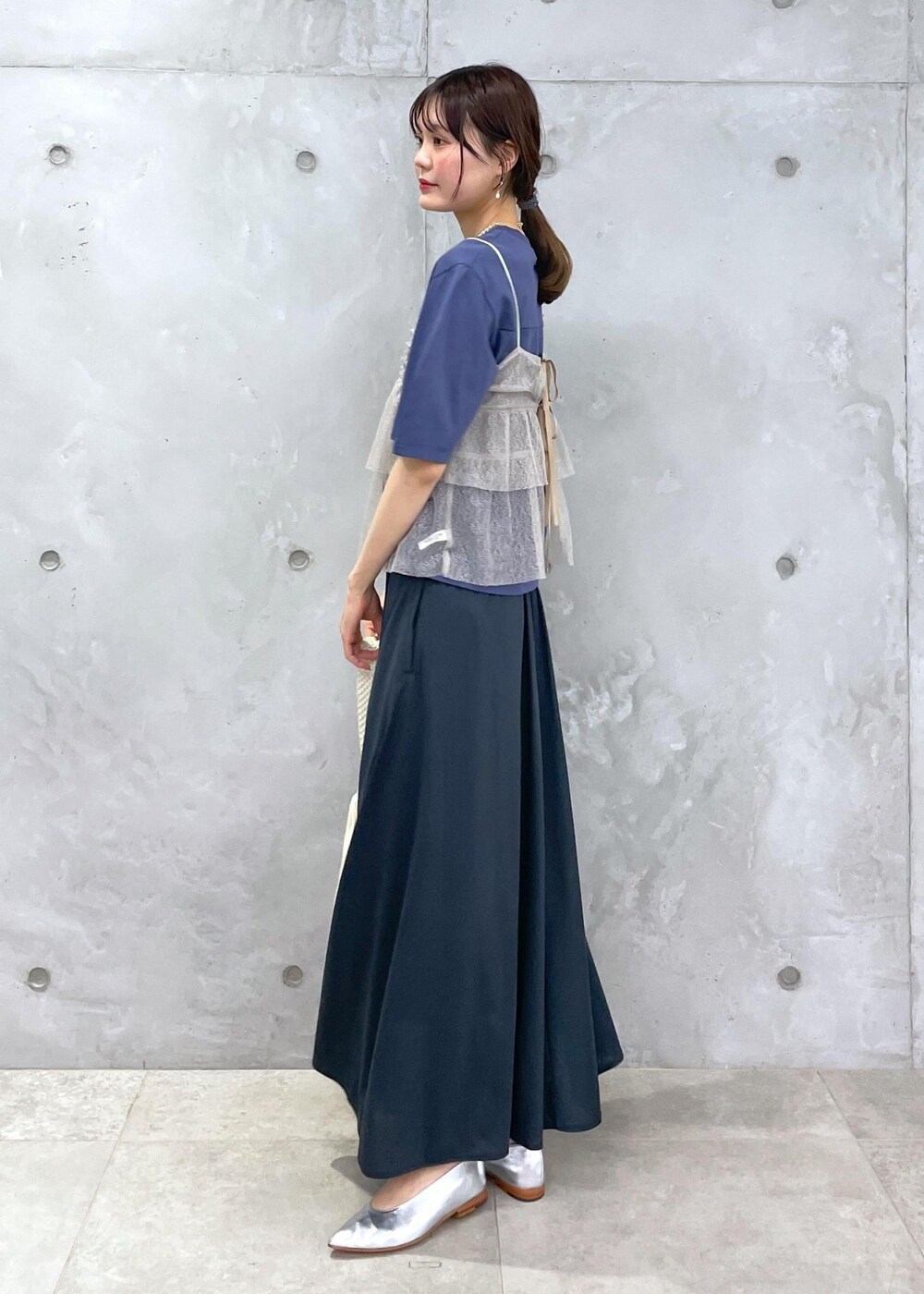 ホワイト系のハンドバッグ、ブルー系のTシャツ/カットソー、ブラウン系のキャミソールを着用したレディースの春コーディネートの4枚目の写真