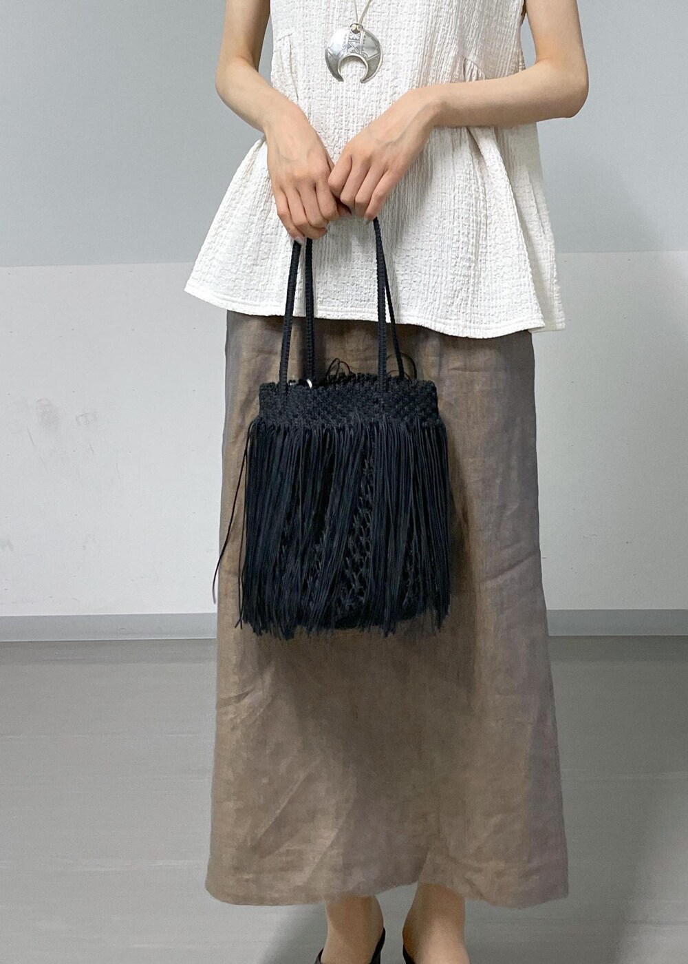 ホワイト系のTシャツ/カットソー、ブラック系のサンダル、ブラック系のトートバッグを着用したレディースの夏コーディネートの6枚目の写真